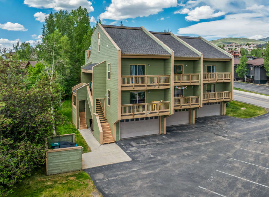 Discover this charming multi-unit property featuring a light green exterior and multiple balconies perfect for enjoying the mountain air.