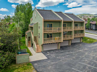 Discover this charming multi-unit property featuring a light green exterior and multiple balconies perfect for enjoying the mountain air.