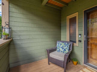 Enjoy your morning coffee on this charming covered porch, complete with a comfortable wicker chair and decorative lantern.