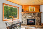 Cozy up by the stone fireplace in this charming living area, perfect for relaxing evenings.