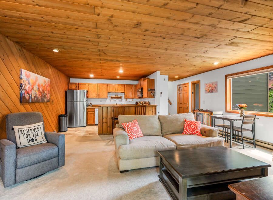 Experience cozy living in this charming space featuring a warm, wood-paneled ceiling and walls.