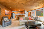 Experience cozy living in this charming space featuring a warm, wood-paneled ceiling and walls.