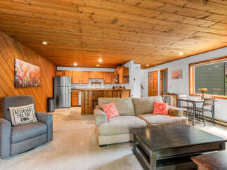Experience cozy living in this charming space featuring a warm, wood-paneled ceiling and walls.