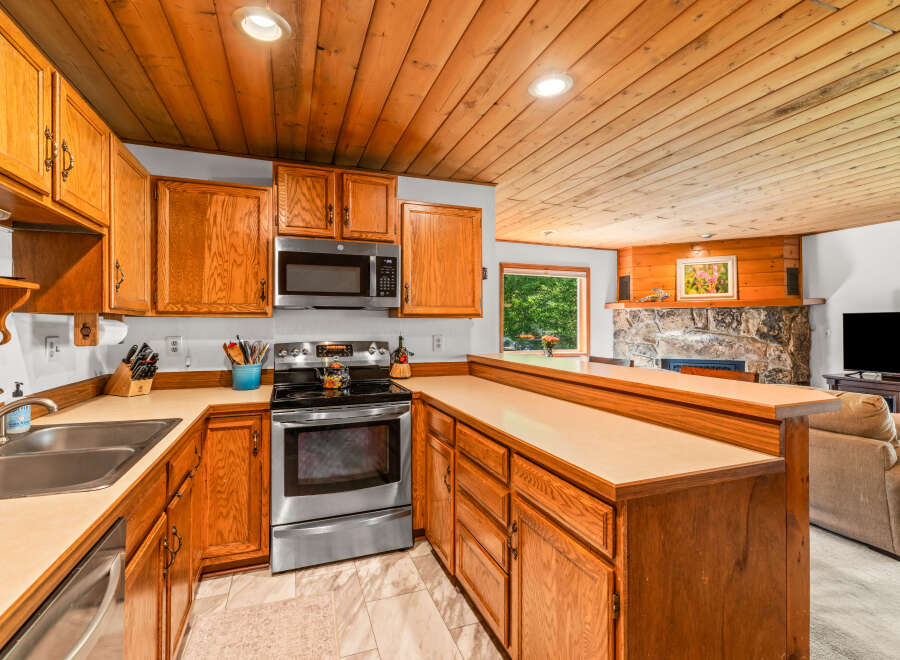 This charming kitchen features warm oak cabinetry and a spacious countertop, perfect for meal preparation.