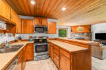 This charming kitchen features warm oak cabinetry and a spacious countertop, perfect for meal preparation.