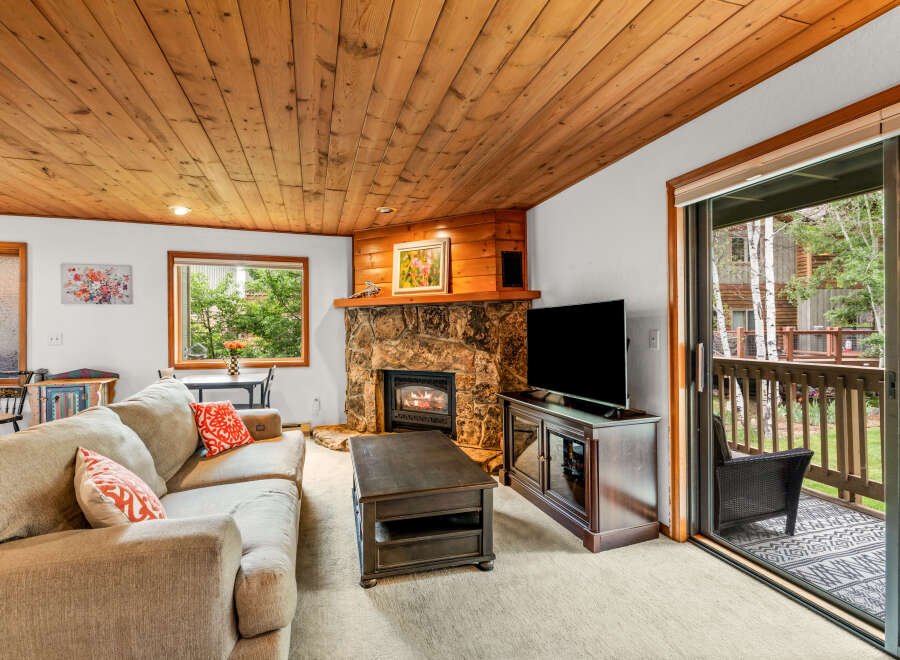 Cozy living room featuring a stone fireplace and a large sectional sofa, perfect for relaxing evenings.