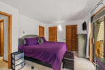 Discover comfort and style in this inviting bedroom, featuring a plush king-sized bed adorned with vibrant purple bedding and a chic upholstered headboard.