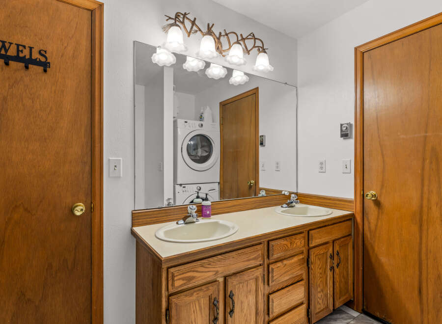 This bathroom features a spacious double vanity with a wooden cabinet base and a light-colored countertop.