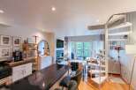 Discover modern living in this open-concept condo featuring a sleek kitchen with a breakfast bar and a cozy living area with a fireplace.