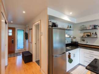 Step into this charming home featuring a welcoming entryway with a wooden door and a stylish black and white striped rug.