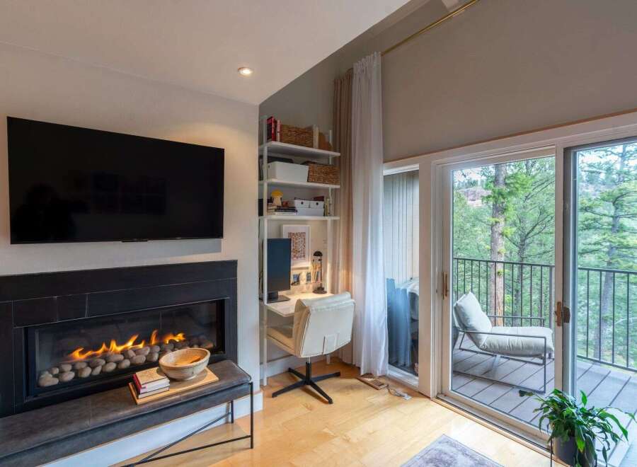 Cozy living room featuring a modern fireplace with a mounted television above.