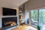 Cozy living room featuring a modern fireplace with a mounted television above.