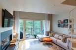 Experience modern living in this stylish living room featuring a large sectional sofa perfect for relaxation and entertaining.