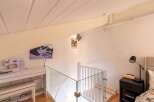 Discover this charming attic space featuring a modern sewing station with a Brother sewing machine and a comfortable bench.