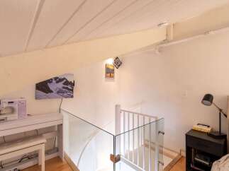 Discover this charming attic space featuring a modern sewing station with a Brother sewing machine and a comfortable bench.