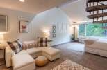 This charming living space features a comfortable sectional sofa adorned with checkered and patterned throw pillows, perfect for relaxing.