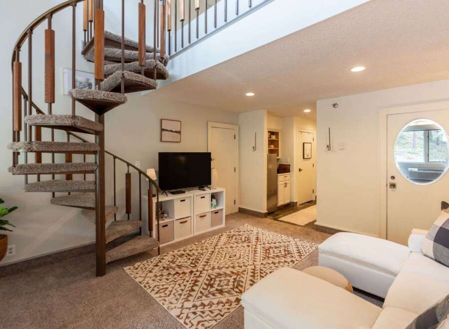 This charming living space features a unique spiral staircase leading to an upper level, perfect for maximizing vertical space.