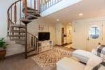 This charming living space features a unique spiral staircase leading to an upper level, perfect for maximizing vertical space.