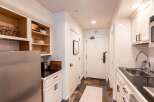 This charming kitchenette features a full-size stainless steel refrigerator and ample cabinet storage, perfect for preparing meals.