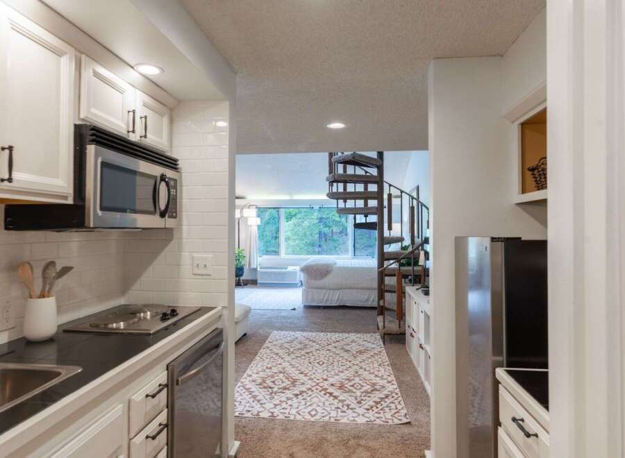 Discover this charming studio apartment featuring a compact yet functional kitchen with stainless steel appliances and ample cabinet space.