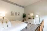 Discover this charming bedroom featuring a cozy bed adorned with plush white pillows and a soft throw.
