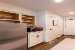 Discover this charming kitchenette featuring a stainless steel refrigerator and ample cabinet space for all your culinary needs.