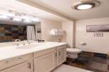 This charming bathroom features a spacious vanity with ample storage and a modern sink, complemented by a decorative tiled backsplash.