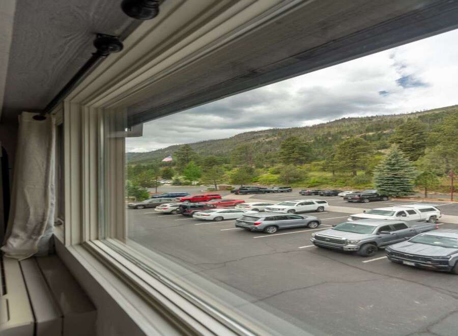 Experience the tranquility of mountain living with this property offering stunning views of a lush, forested hillside.