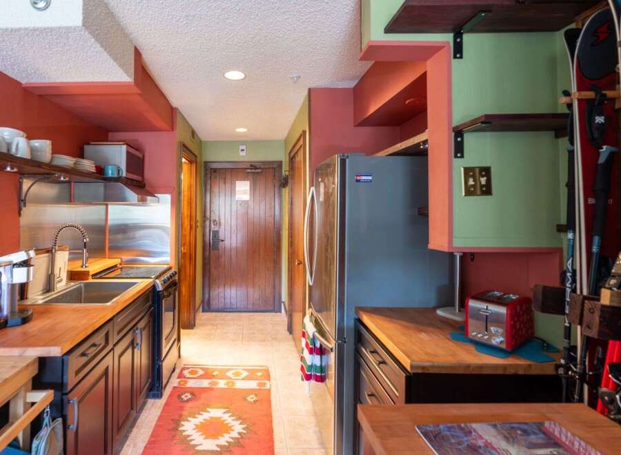 Discover this charming kitchen featuring warm wooden countertops and dark cabinetry, perfect for meal preparation.