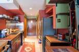 Discover this charming kitchen featuring warm wooden countertops and dark cabinetry, perfect for meal preparation.