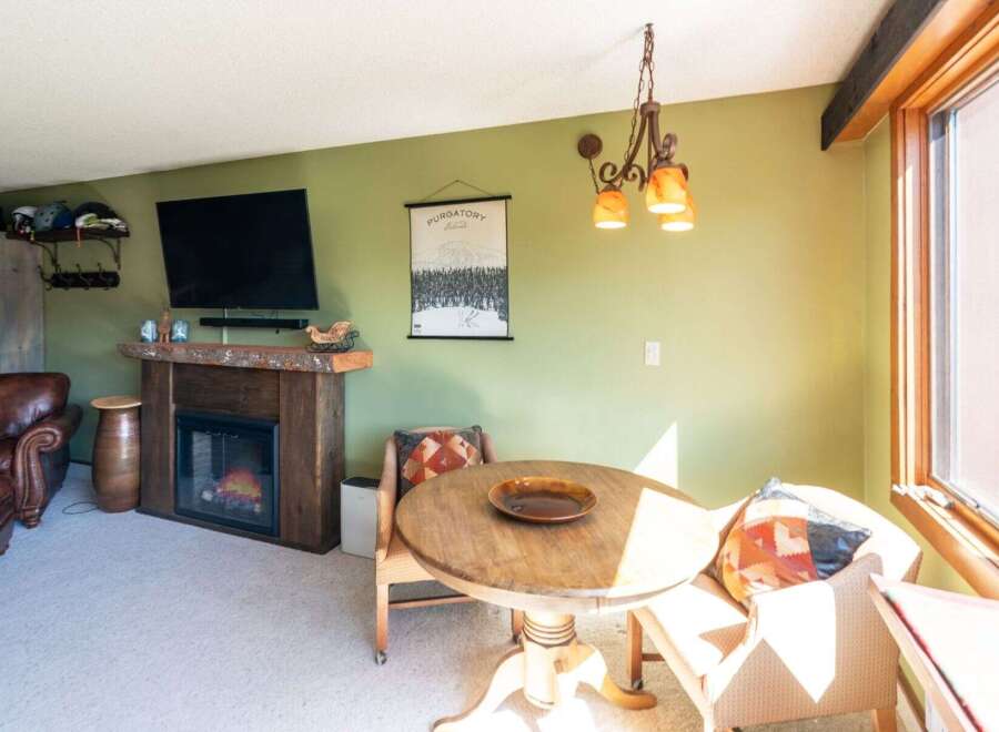 Cozy living space featuring a rustic wood-burning fireplace, perfect for warming up after a day on the slopes.