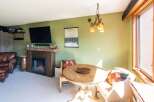 Cozy living space featuring a rustic wood-burning fireplace, perfect for warming up after a day on the slopes.