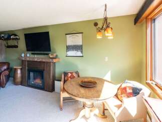 Cozy living space featuring a rustic wood-burning fireplace, perfect for warming up after a day on the slopes.