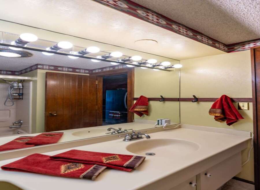 Step into this charming bathroom featuring a spacious vanity with a double sink and ample counter space.
