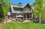 Experience luxury mountain living with this stunning property featuring a spacious outdoor patio and entertainment area, perfect for enjoying the serene surroundings.