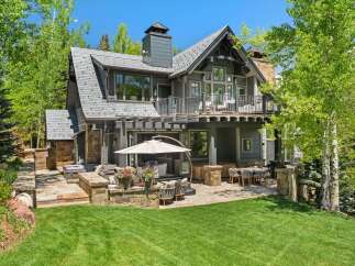 Experience luxury mountain living with this stunning property featuring a spacious outdoor patio and entertainment area, perfect for enjoying the serene surroundings.