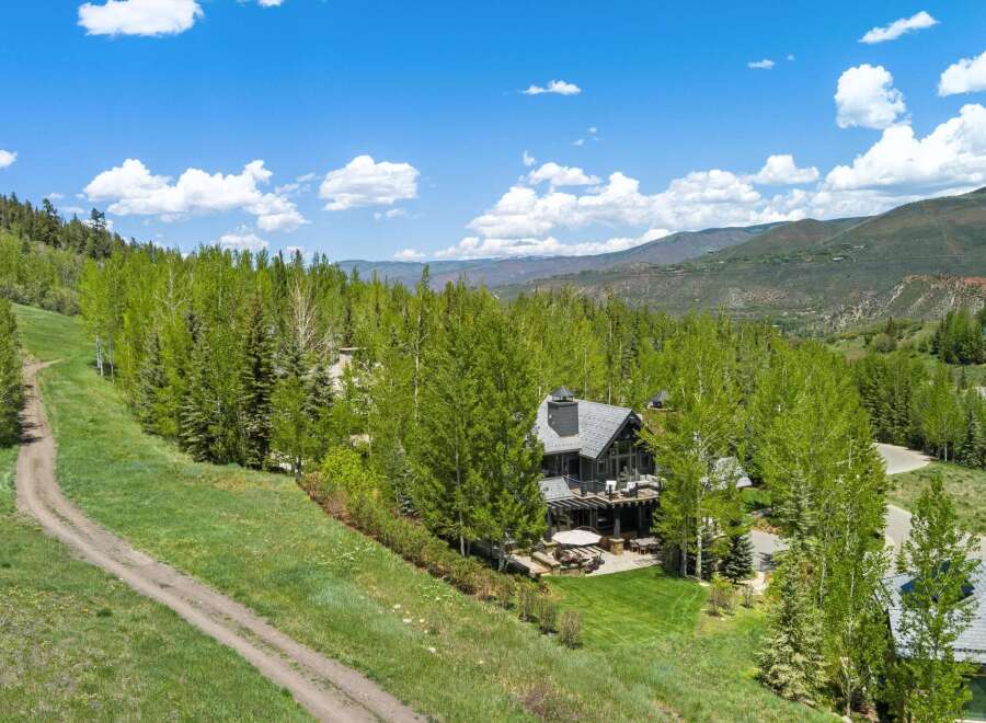 Nestled amidst lush greenery and mature trees, this stunning mountain home offers breathtaking panoramic views.
