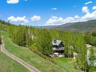 Nestled amidst lush greenery and mature trees, this stunning mountain home offers breathtaking panoramic views.