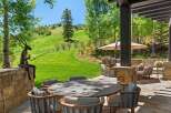Experience luxurious outdoor living with this stunning patio featuring a round dining table and comfortable seating, perfect for al fresco meals.