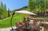 Enjoy breathtaking mountain views from this stunning outdoor living space, complete with a cantilever umbrella for shade and comfortable seating.