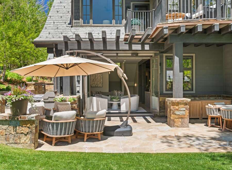 Enjoy outdoor living at its finest with this expansive patio featuring comfortable seating and a large cantilever umbrella for shade.