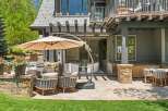 Enjoy outdoor living at its finest with this expansive patio featuring comfortable seating and a large cantilever umbrella for shade.