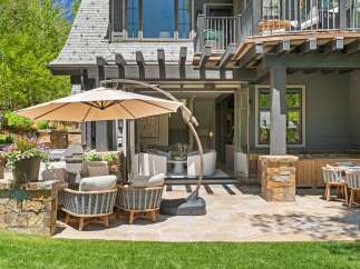 Enjoy outdoor living at its finest with this expansive patio featuring comfortable seating and a large cantilever umbrella for shade.