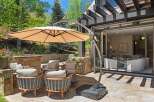 Enjoy outdoor living at its finest with this stunning patio featuring comfortable seating and a large cantilever umbrella for shade.