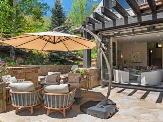 Enjoy outdoor living at its finest with this stunning patio featuring comfortable seating and a large cantilever umbrella for shade.