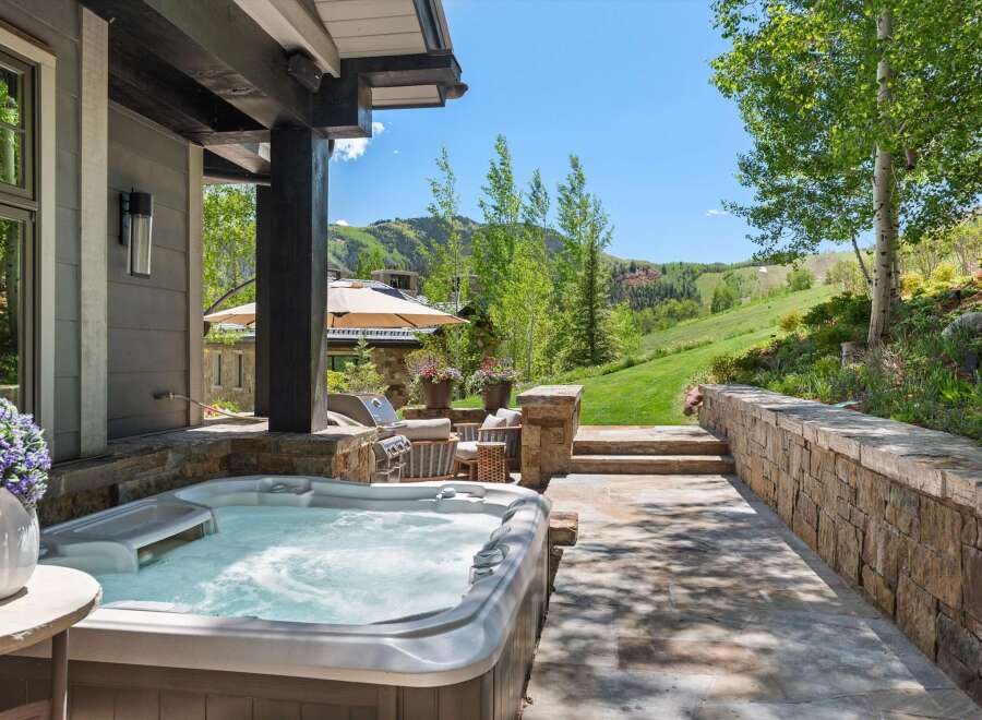 Experience ultimate relaxation with this luxurious outdoor living space, featuring a bubbling hot tub perfect for unwinding.