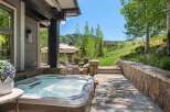 Experience ultimate relaxation with this luxurious outdoor living space, featuring a bubbling hot tub perfect for unwinding.