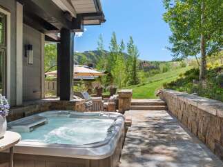 Experience ultimate relaxation with this luxurious outdoor living space, featuring a bubbling hot tub perfect for unwinding.