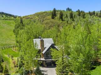 Nestled amidst lush greenery and mature trees, this stunning mountain home offers a serene escape.