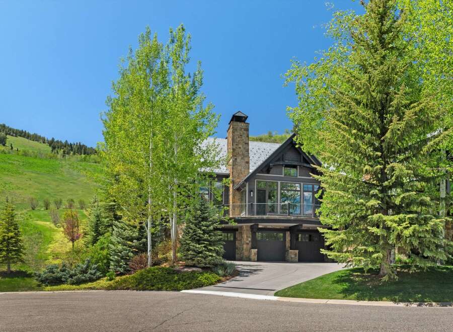 Experience luxury mountain living in this stunning home, nestled against a backdrop of rolling green hills and mature trees.